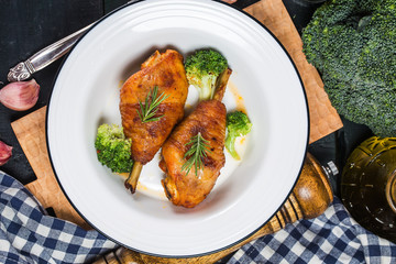 Chicken Legs with Vegetables on wooden table.