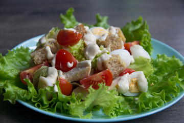 Salad with chicken, red tomatoes, eggs, cabbage, croutons and Caesar sauce