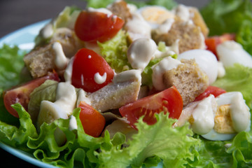 Salad with chicken, red tomatoes, eggs, cabbage, croutons and Caesar sauce
