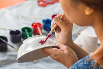 Close-up hands holding a bowl during painting in Lampang province, Thailand