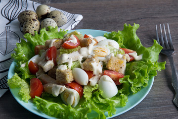 Salad with chicken, red tomatoes, eggs, cabbage, croutons and Caesar sauce