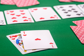 playing cards on a green table in different combinations close-up