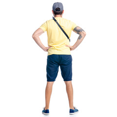 Man in shorts and cap standing looking on white background isolation, back view