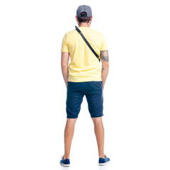 Fototapeta premium Man in shorts and cap standing looking on white background isolation, back view