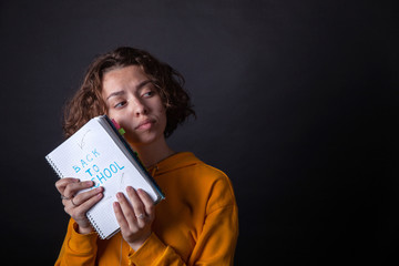 Young caucasian girl holding notebook with Back to School