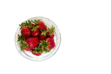 Ripe, juicy, fresh, red strawberries with green leaves in a glass plate. White background. Isolated.