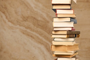 Collection of old books vertical stack on beige background
