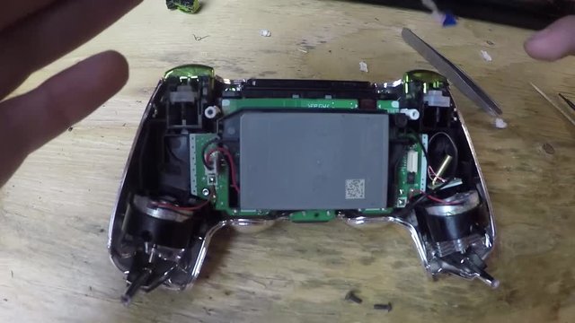 Fixing a circuit board inside of a video game controller.