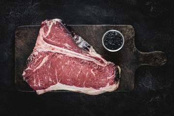 Dry Aged Beef Raw T-bone Steak on Vintage Cutting Board - 276764320