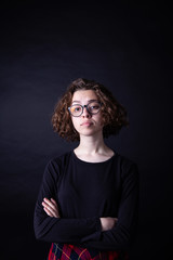 Young caucasian highschool girl with curly hair and round eyeglasses