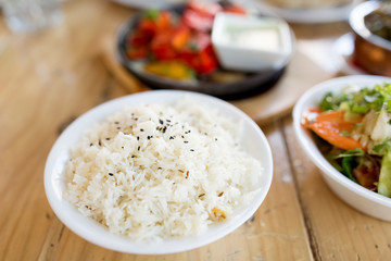 food, south asian cuisine, culinary and cooking concept - close up of boiled rice in bowl on table of indian restaurant