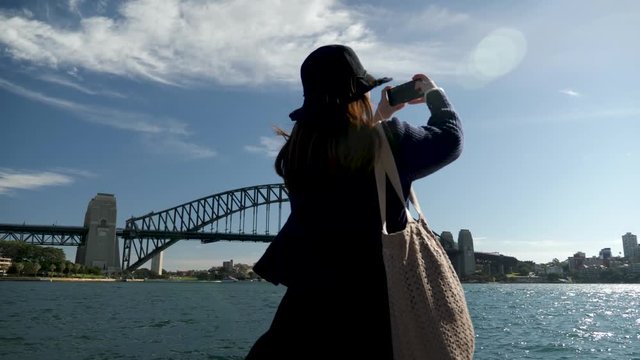 young female asian tourist taking paranormal photo near opera house, darling harbour