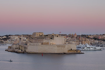 Obraz premium Fort St. Angelo at sunset with the Grand Harbor in Vittoriosa during sunset, Malta.