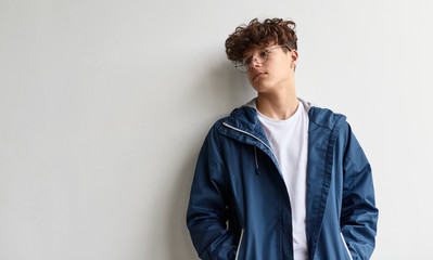 Dreamy youngster leaning on wall