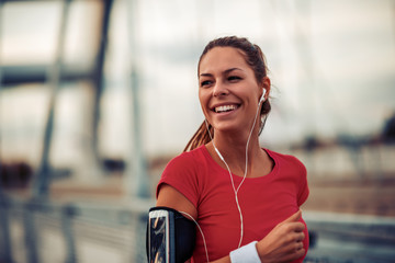 Young fitness woman running over the bridge