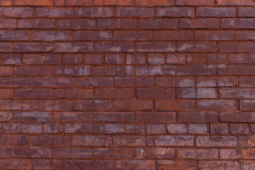 Old red painted brick wall with beautiful rows of speckled bricks.