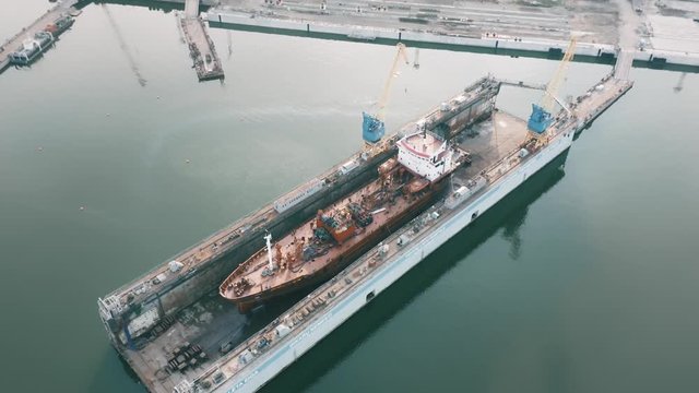 Ship being built or repaired in shipyard, construction site, aerial view