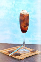 Non-alcoholic cola cocktail with ice, pomegranate syrup and a scoop of vanilla ice cream in a...
