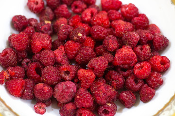 Red Raspberries in a square wooden pint container full isolated on white. Red raspberries in a white container. Red raspberry close-up