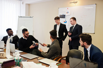 Six multiracial business mans at office at table. Diverse group of male employees in formal wear discussing.