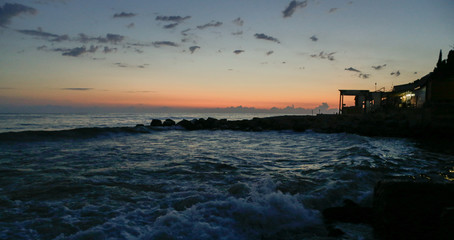 Obraz premium golden sunset at blue sea with waves