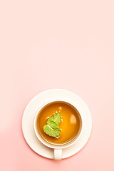 Creative concept of white ceramic cup with herbal green or black tea with mint leaves