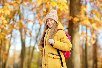 school, education and season concept - happy student girl with schoolbag at autumn park