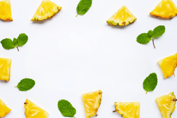 Frame of fresh pineapple  slices with mint leaves on white