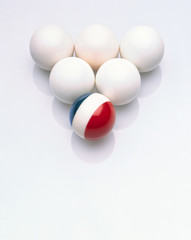 Five white balls with an odd ball in blue white and red colours 