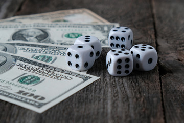 Dices, US dollar banknotes on the background of the old wooden table, the concept of gambling.
