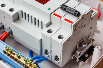 Double input automatic circuit breaker and voltage limiter closeup in the white plastic mounting box