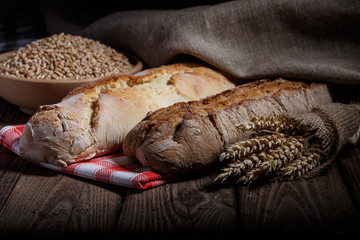 Obraz premium Assortment of baked bread on wooden table background
