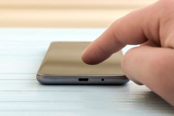 man presses his finger on the screen of the phone, close-up