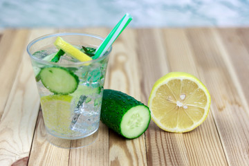 refreshing drink with ingredients, cucumber water on a wooden table