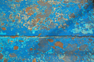 The texture of the iron metal painted blue paint old battered scratched cracked ancient rusty metal sheet wall with corrosion. The background