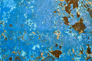 The texture of the iron metal painted blue paint old battered scratched cracked ancient rusty metal sheet wall with corrosion. The background