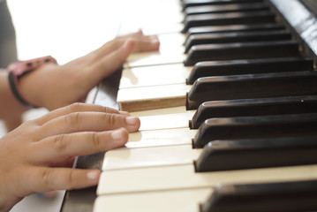 Obraz premium child hands play the old piano