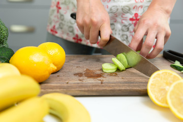 Woman chopping green vegetables for detox smoothie at home. Healthy eating, vegetarian food, dieting