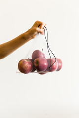 Reusable eco-friendly bag full of fresh seasonal apples on white background