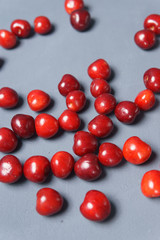 Red sweet cherry scattered on a gray background