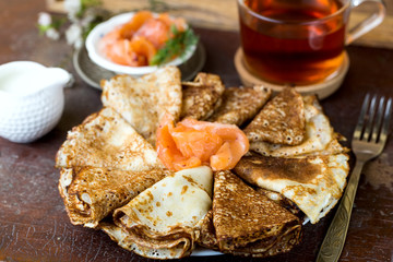 plate of pancakes with salted red fish for Breakfast on a tray