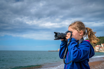Obraz premium Young girl photographing the sea