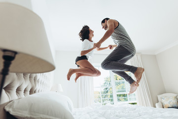Fototapeta Couple jumping on bed obraz