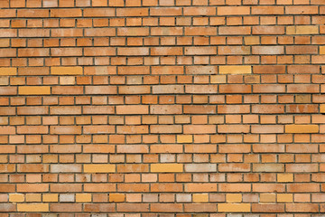 The texture of the brick wall of yellow-orange bricks