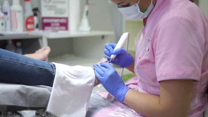 The girl in the center of the hardware pedicure do the procedure.