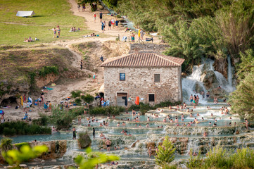 Grosseto, Tuscany. Wwaterfalls of Saturnia with people in swimwear. The Terme di Saturnia are made...