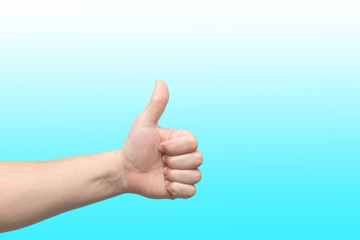 Closeup of male hand showing thumbs up sign against blue gradient background
