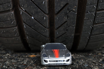 Reality check, illustrated by placing toy car (false impression) in front of real car's tyre (reality)