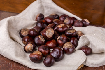 chestnuts in bowl on wooden background
