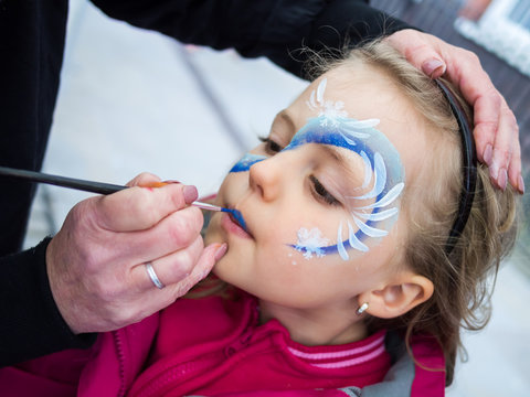 Little girl having her face painted